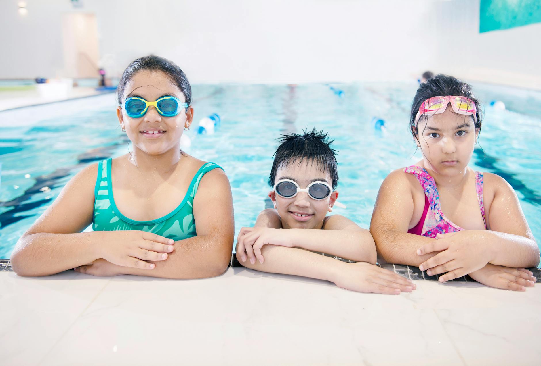 Children testing outdoor play gear and toys in a backyard setting — what is the best age to start swimming lessons for