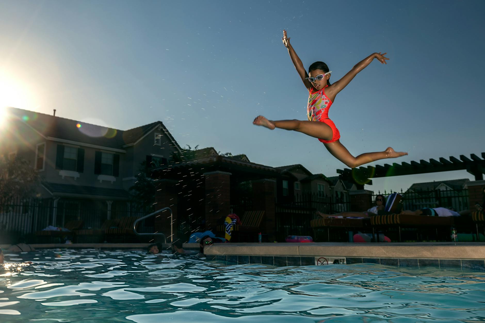 Children testing outdoor play gear and toys in a backyard setting — what pool safety essentials do families with young